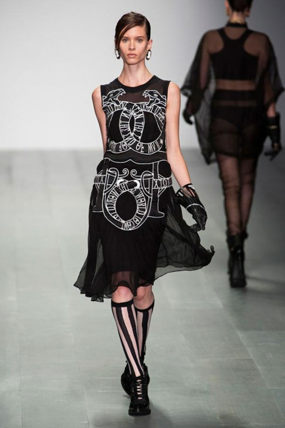 vestido preto com palavras e símbolos bordados em latim