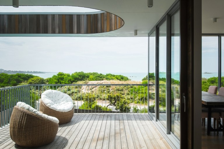 Varanda com madeira termica cobrindo duas poltronas de rattan
