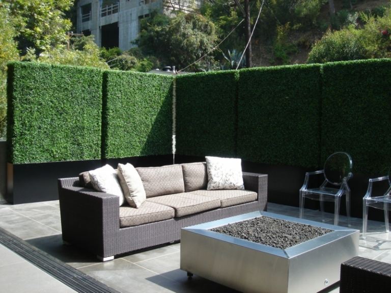 Proteção de privacidade no jardim Idéia de cerca viva sofá de vime moderno, mesa de centro lareira