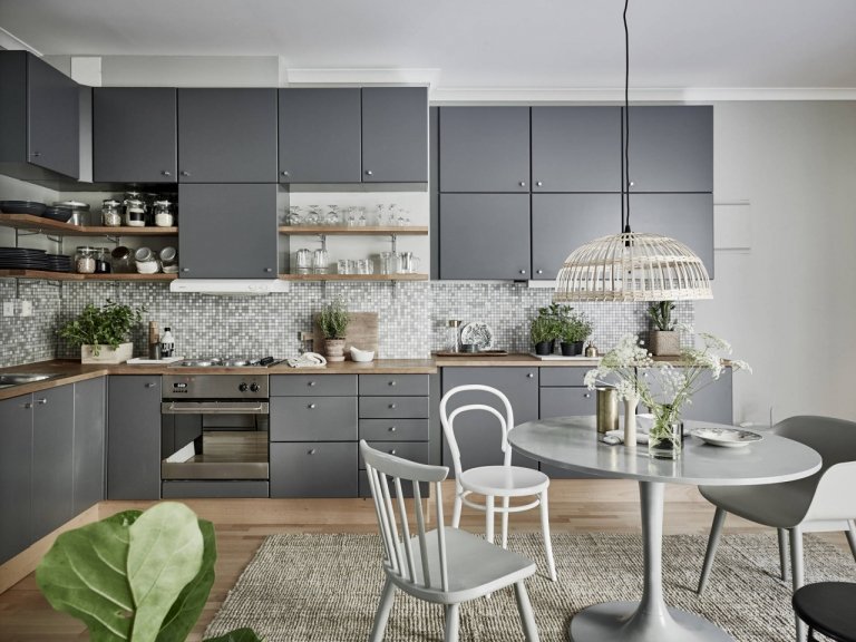 Cozinha escandinava com cadeira de madeira e cozinha cinza com mosaico de azulejos