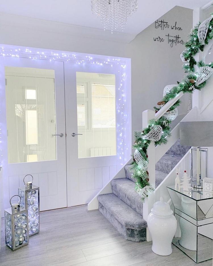Decorações de Natal no corredor com luzes de fadas brancas e frias e decorações em prata e branco