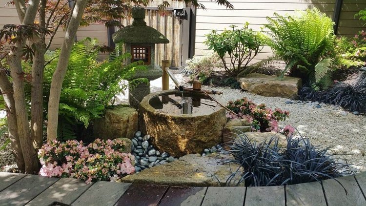 elemento de água e lanterna de pedra no jardim japonês