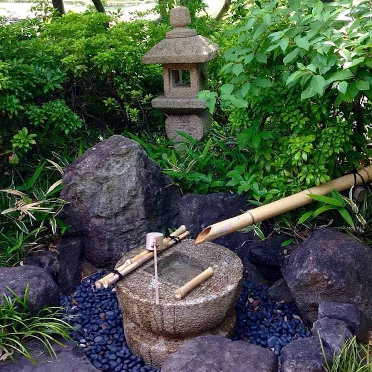 Água japonesa com rochas, seixos e bambu