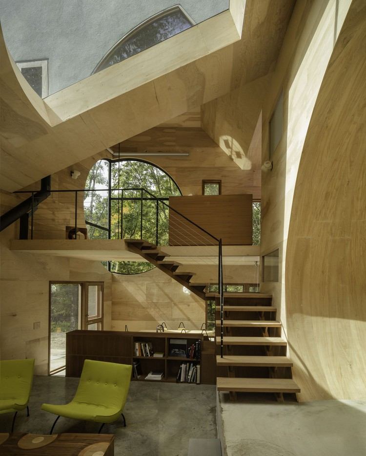 Casa solar em madeira aberta-interior-clarabóia-escada de madeira