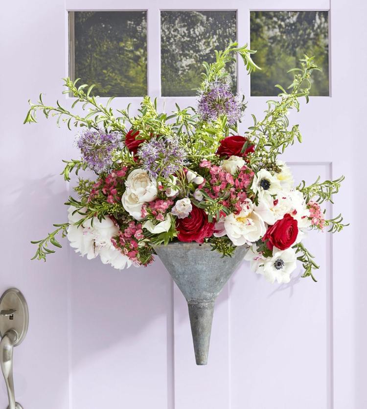 Flores de verão no funil para uma decoração de verão do lado de fora da porta da frente