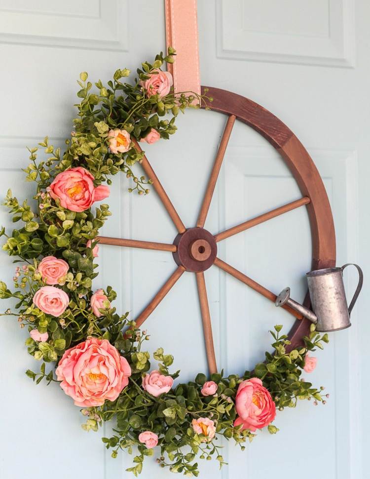 Guirlanda de porta original feita de roda de madeira com rosas e um mini regador