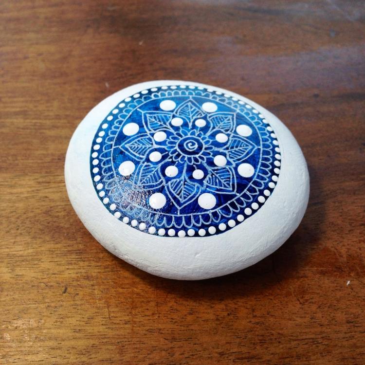 pintando pedras mandala azul com motivo de flor círculo