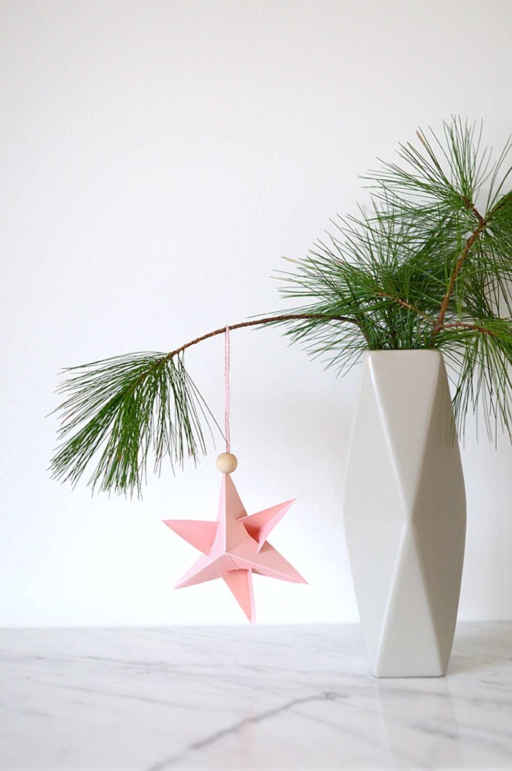 Decoração de Natal lindamente projetada com galhos de árvores em um vaso decorado com estrela de papel pendurada com conta de madeira