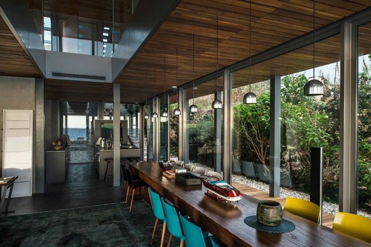 casa de praia estilo mediterrâneo mesa de jantar cadeiras lâmpadas azul claro amarelo