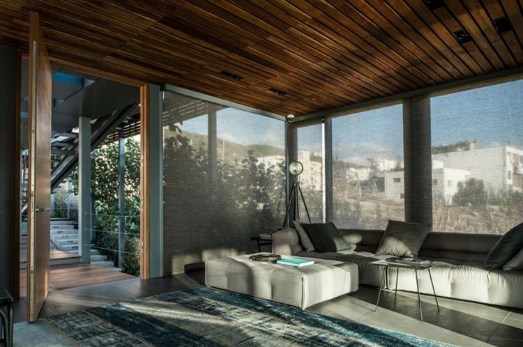 estilo mediterrâneo casa de praia sofá cinza tapete azul janela almofada