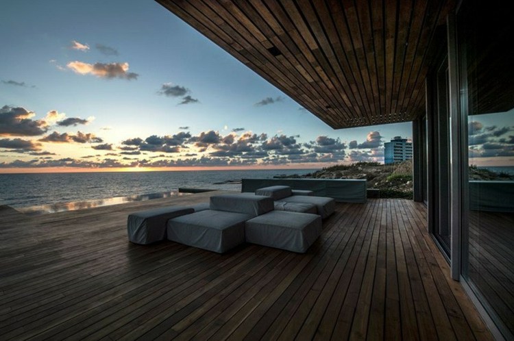 casa de praia estilo mediterrâneo piso de madeira banqueta lounge pôr do sol