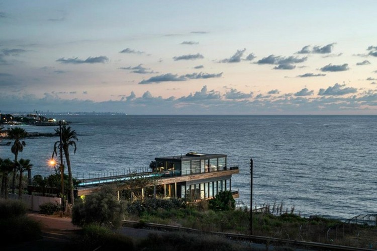 Casa de praia em estilo mediterrâneo, vista para o mar, janela de vidro e píer frontal