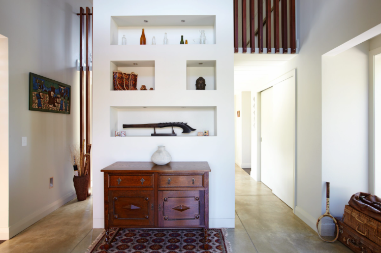 Coluna de apoio da sala com alcovas e estantes com decoração retro