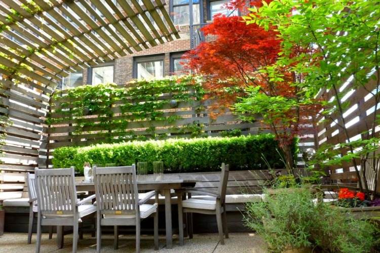 terraço urbano com divisórias de madeira e sombra na mesa de jantar