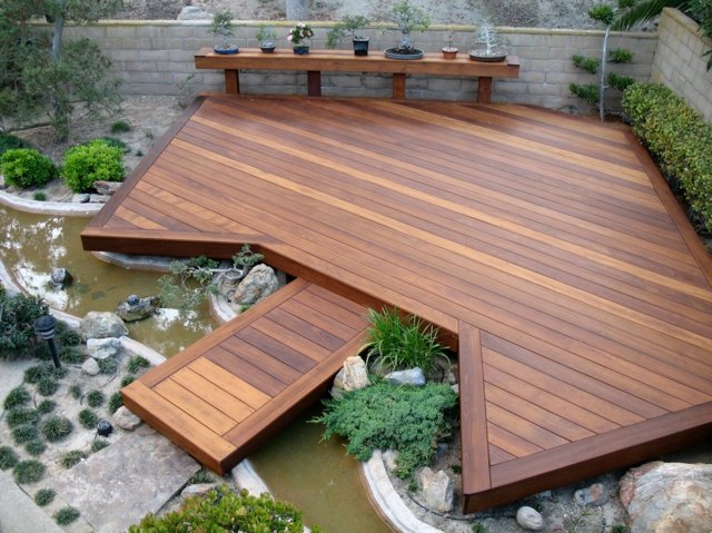 Piso do terraço de madeira cobrindo jardim lagoa banco de jardim de pedra