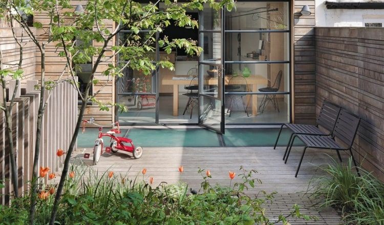 Pequeno jardim citadino com terraço e divisórias de madeira para o vizinho