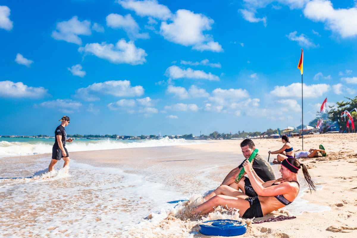 mulher que faz exercícios na praia levanta pesos no mar