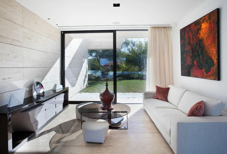 Sala de estar com azulejos travertino-branco-sofá-banqueta-vidro-sofá-mesa