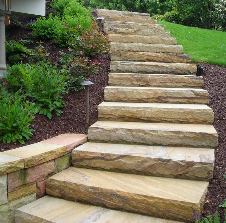Escadas de pedra natural no jardim com curvas modernas