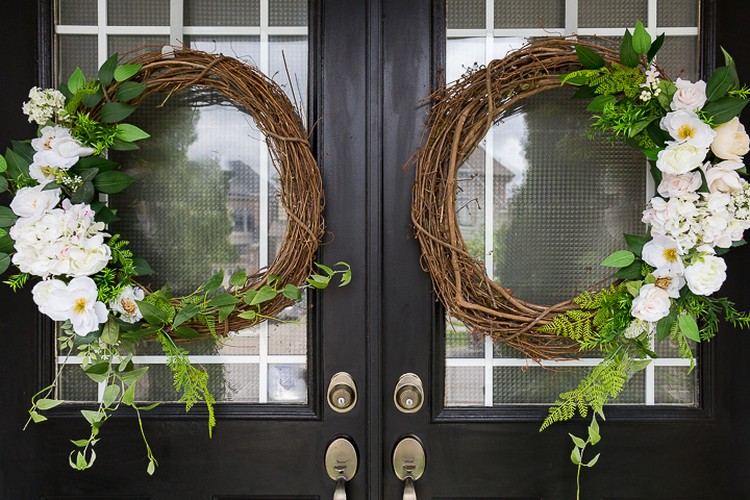 Decoração de porta para porta dupla com duas grinaldas de salgueiro decoradas com flores brancas