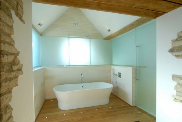 Casa de conversão de celeiro com banheira com piso de madeira