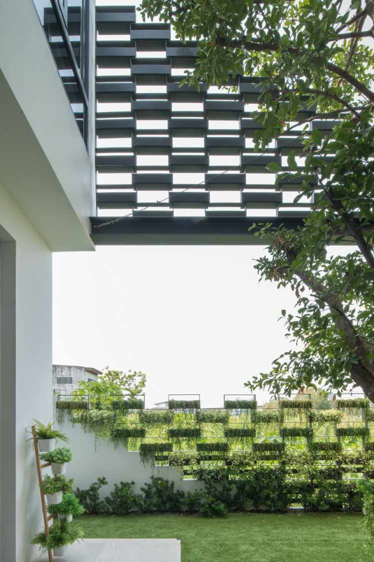 pátio interno canteiros de flores com fachada de casa verde feitos de aço