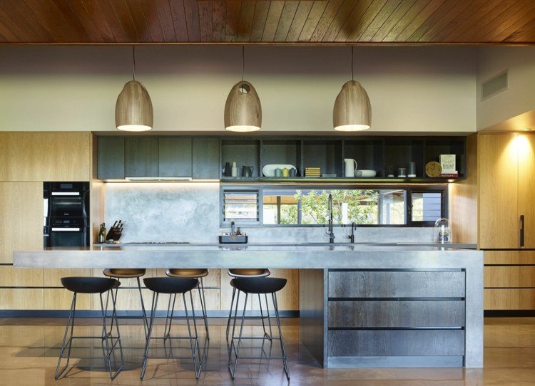 Ilha de cozinha e balcão de café da manhã feito de concreto em um, combinado com madeira