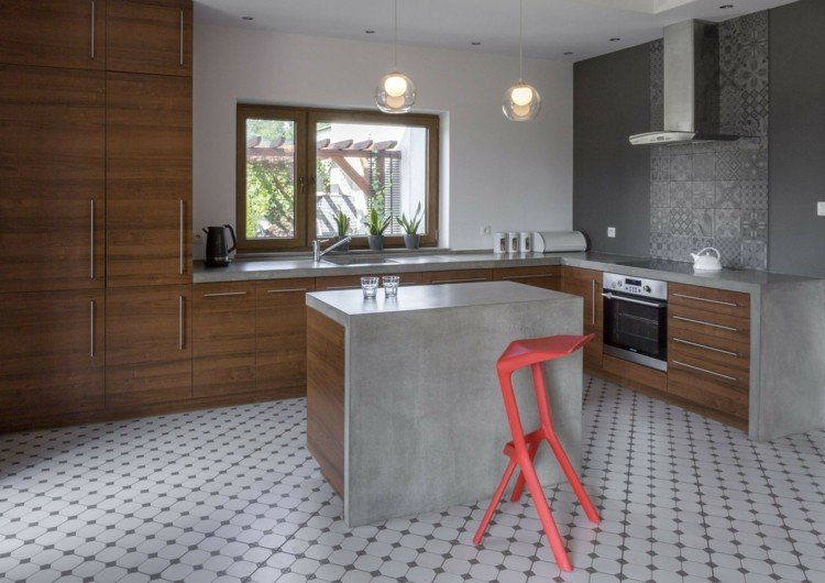 Cozinha espaçosa com aparência de concreto com uma pequena ilha de cozinha e proteção contra respingos de patchwork