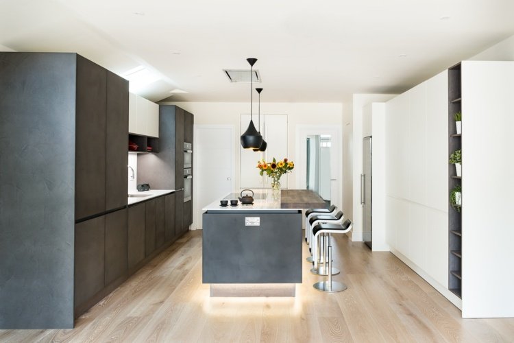 A iluminação indireta enfatiza a aparência de concreto na cozinha