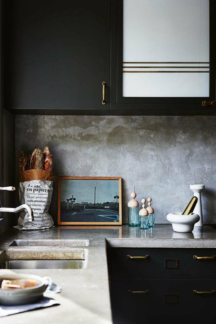 Cozinha preta estilo country com bancada de concreto e fundo de azulejos
