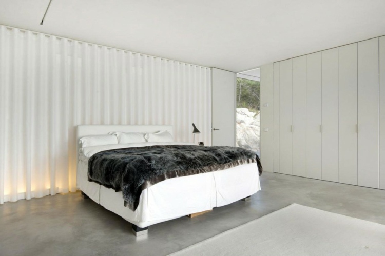 quarto design cama móveis brancos villa de concreto à beira-mar