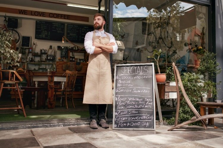 jovem cozinheiro deixando a barba crescer em frente ao restaurante