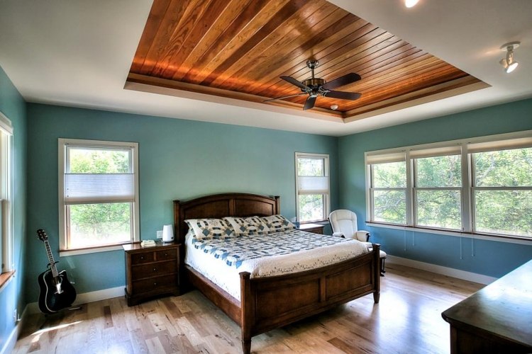 parede-turquesa-quarto-piso de madeira-cama-teto-madeira maciça-branco-janela-ventilador