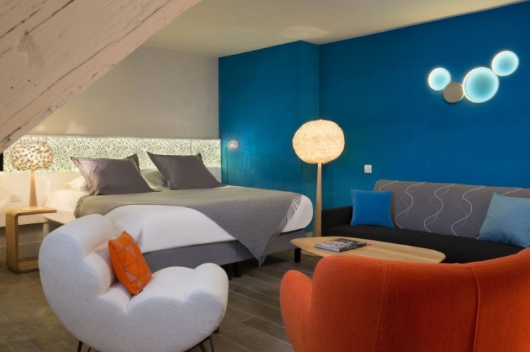 parede-cor-turquesa-quarto-cama-assento-estofamento-anos 50-iluminação indireta-laranja