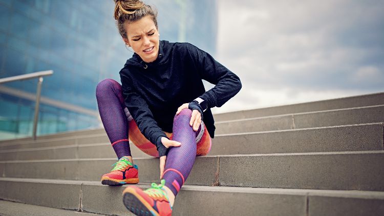 cãibras na panturrilha músculos doloridos treinamento escada sentado roupas esportivas leggings calçados esportivos moletom