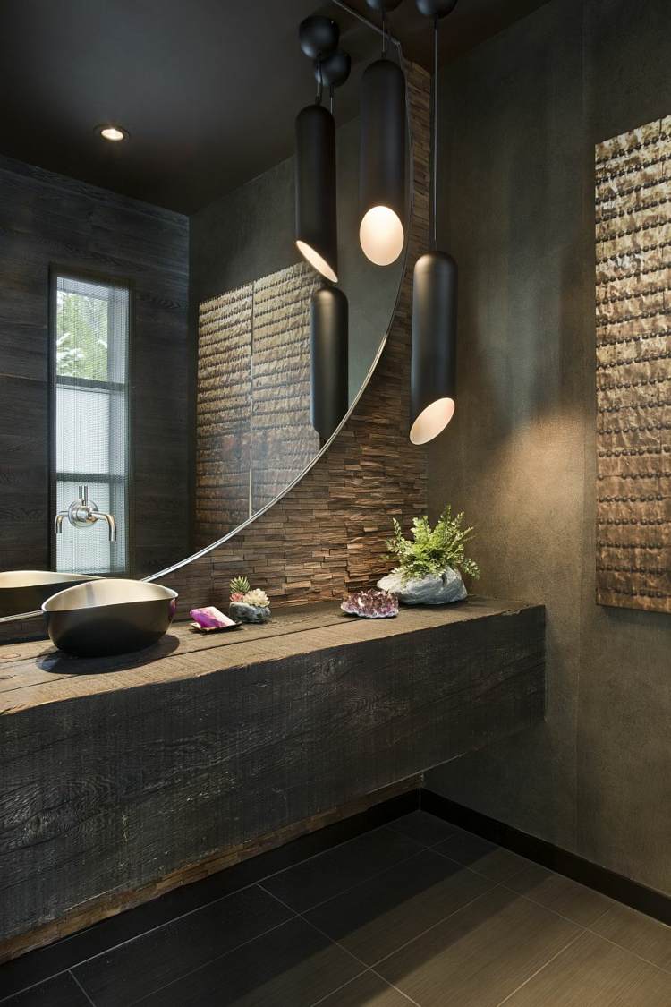 lavatório feito de madeira rústica vigas de madeira parede de pedra espelho redondo luz pendente moderna