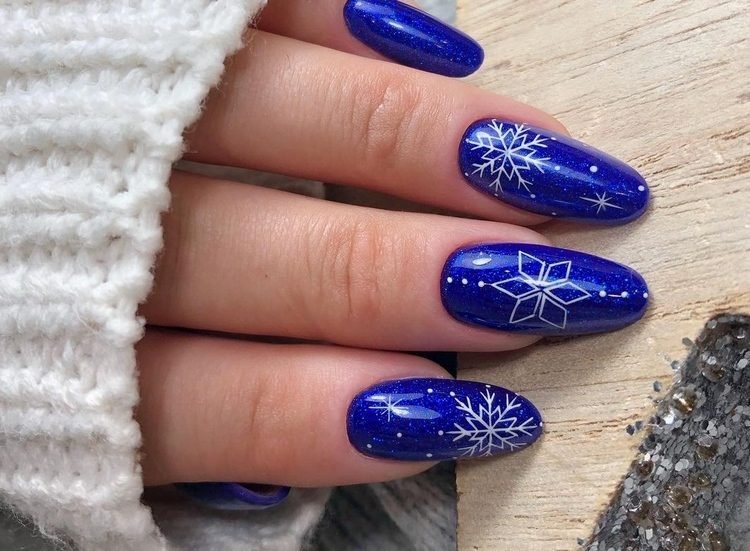 Unhas de inverno em azul marinho com desenhos de floco de neve