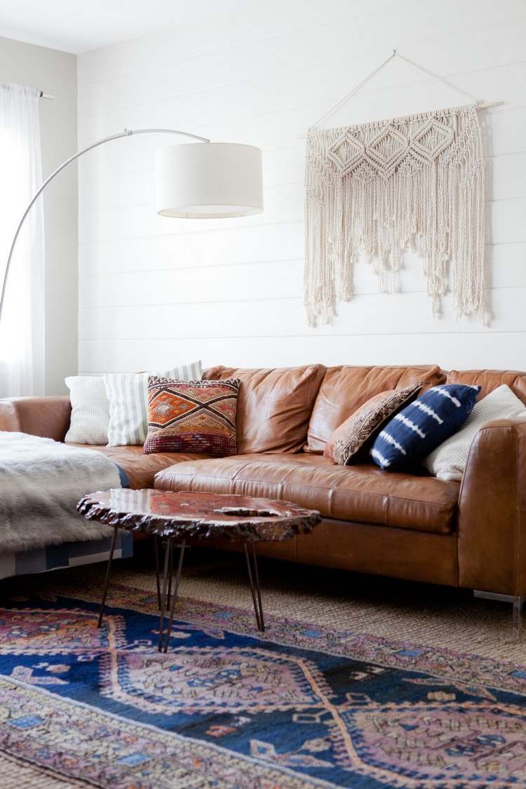 o que se passa com sofá marrom com parede branca, carpete e mesa de madeira