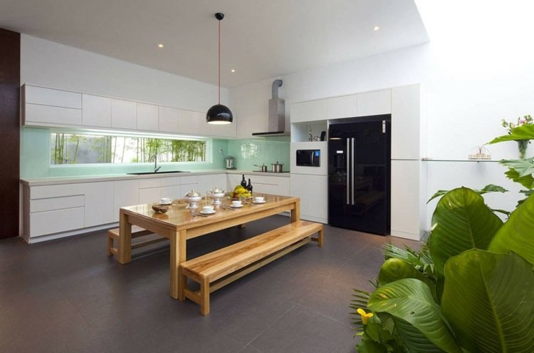 Cozinha aberta com parede traseira verde pastel e design de armário minimalista