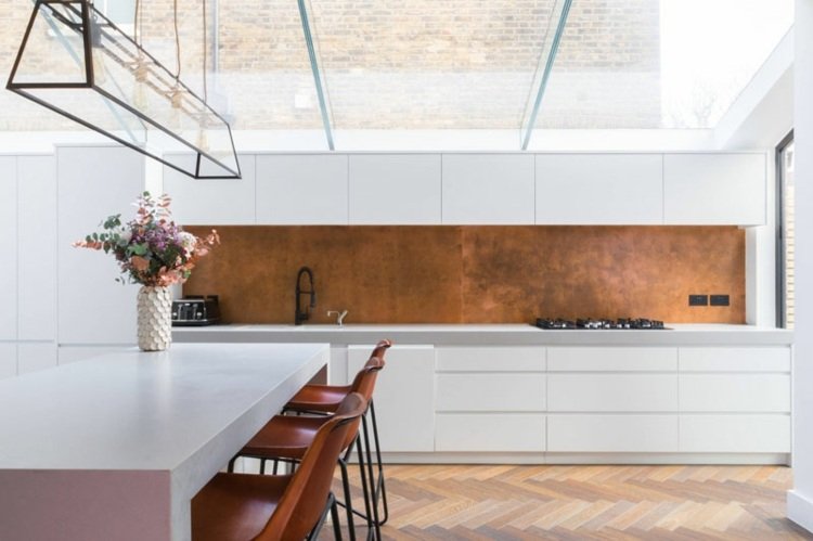 Cozinha com parede traseira branca com cobre para um ambiente moderno e aconchegante e como um destaque de cor