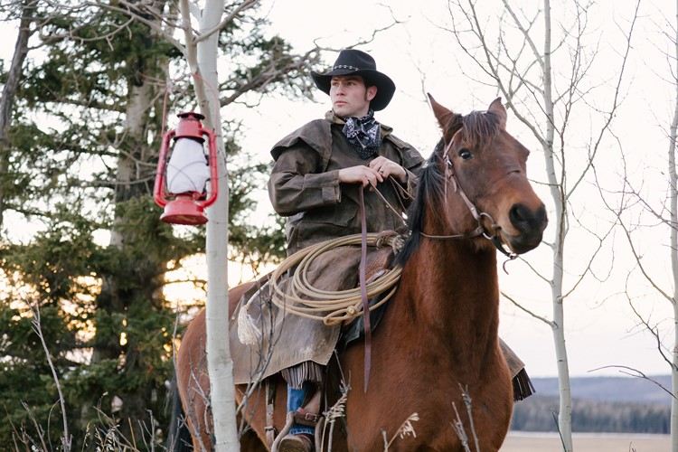 Cowboy a cavalo com laço, lenço bandana, casaco de couro