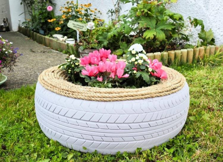 Arco branco decorado com corda e plantado com ciclâmen