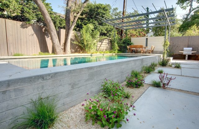 Projeto paisagístico moderno perenes piscina seixos