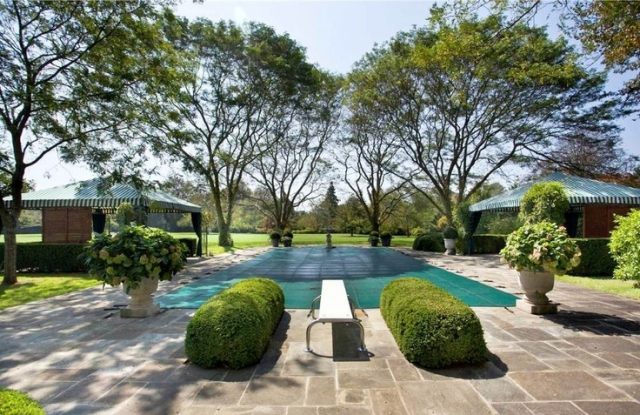 Atmosfera de jardim de árvores com azulejos de terracota na área da piscina