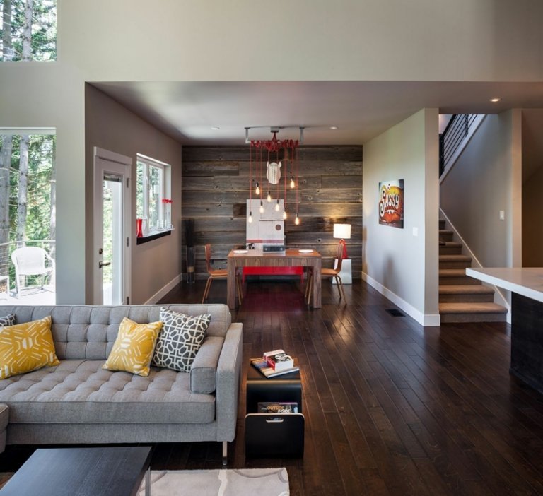 sala de estar estilo country com painéis de madeira na parede sofá cinza amarelo acento travesseiros parquet