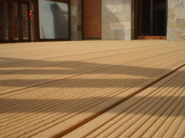 Piso de terraço, colocação de tábuas de madeira com os pés descalços