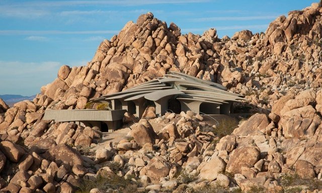 residência contemporânea em uma colina rochosa com vista para uma casa no deserto