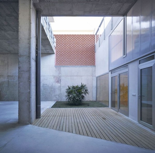 Casa de concreto com terraço de madeira com jardim interno