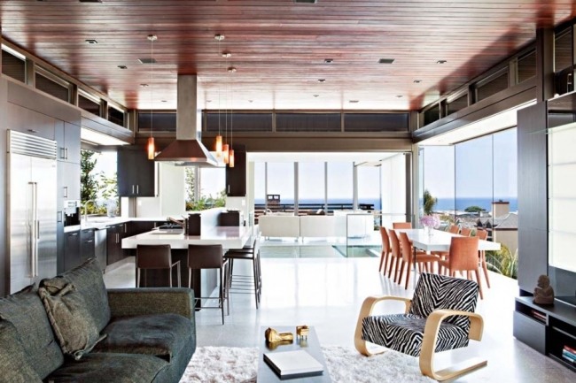 Apartamento eclético com vista para o mar, móveis de design, padrões animais, poltronas modernas