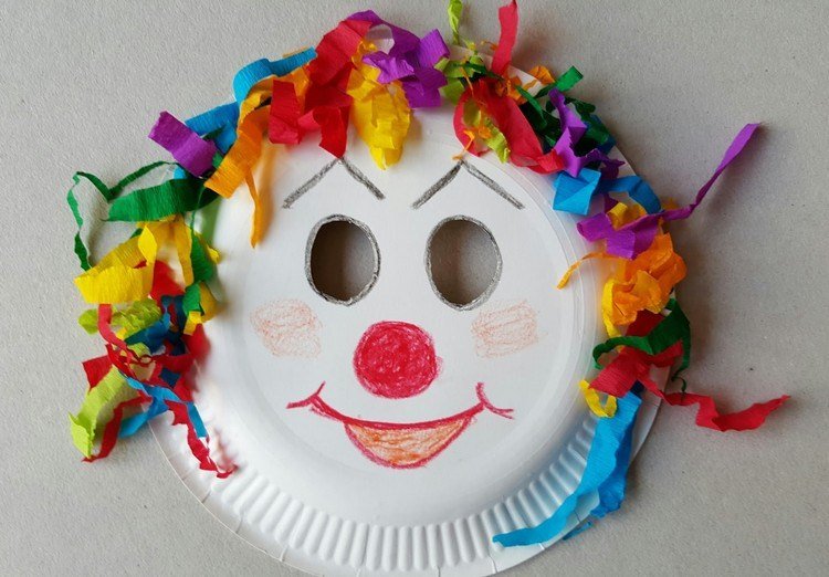 Máscara de palhaço feita de prato de papel com pedaços de papel colorido
